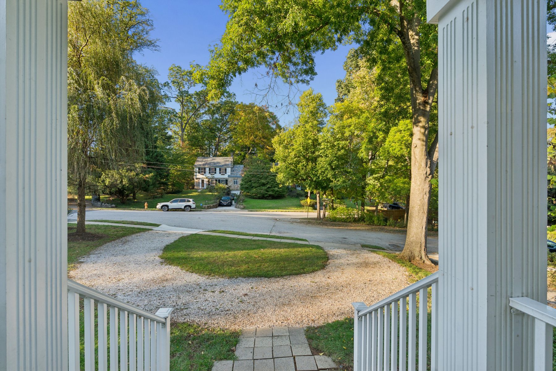 View from the front steps over the circular drive to the tree-lined corner